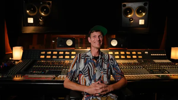 Mann mit T-Shirt sitzt in einem Studio
