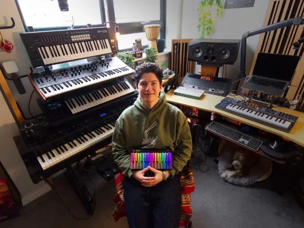 Junger Mann ist umgeben von vielen Keyboards